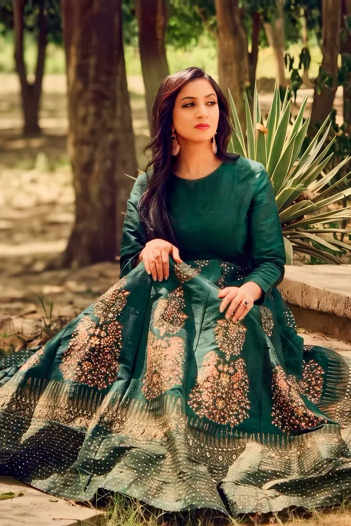 Portrait of Malaika Faisal in a green embroidered dress seated outdoors in daylight